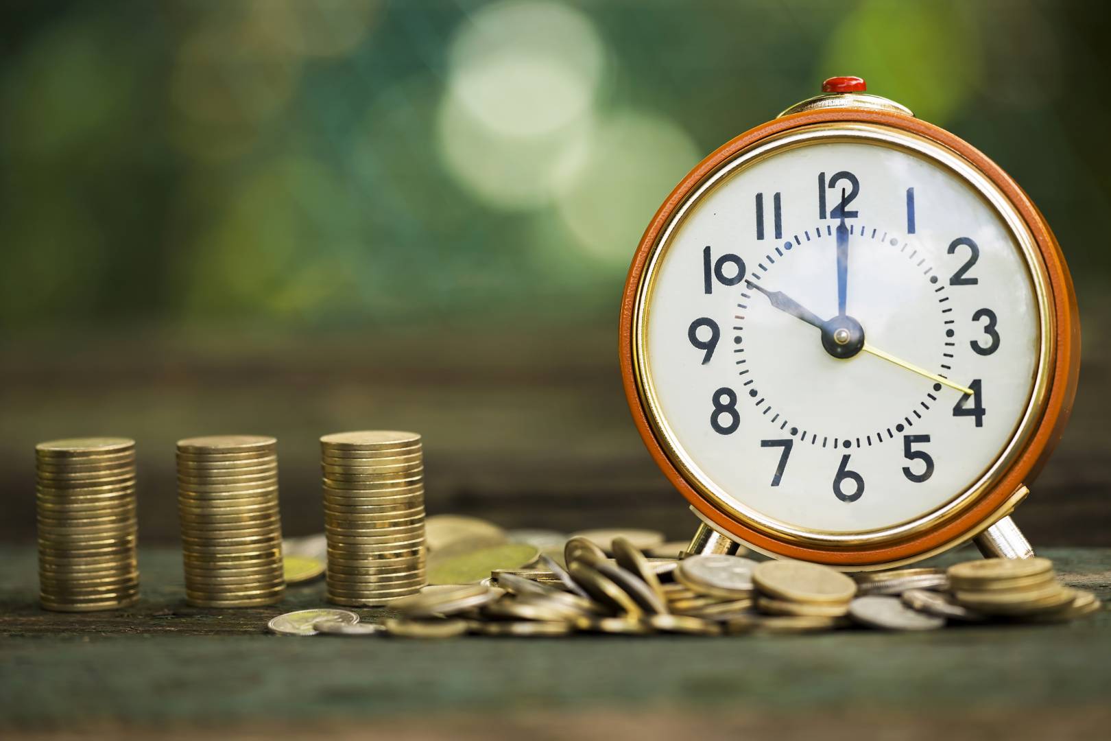 Regras de aposentadoria: relógio e moedas sobre uma mesa
